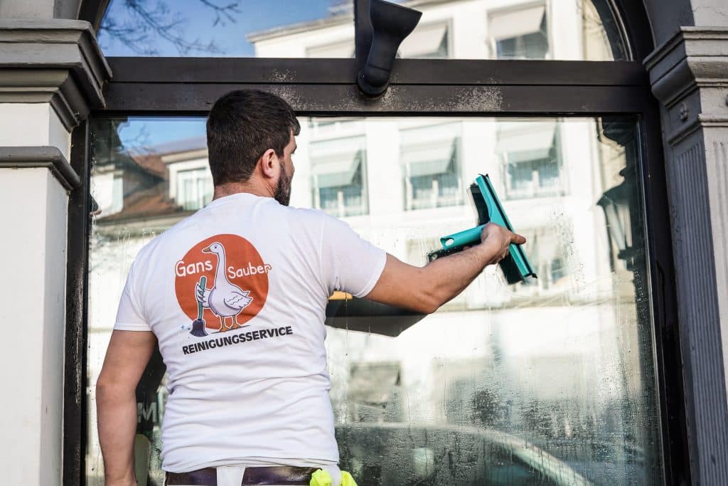 Mann reinigt Schaufenster